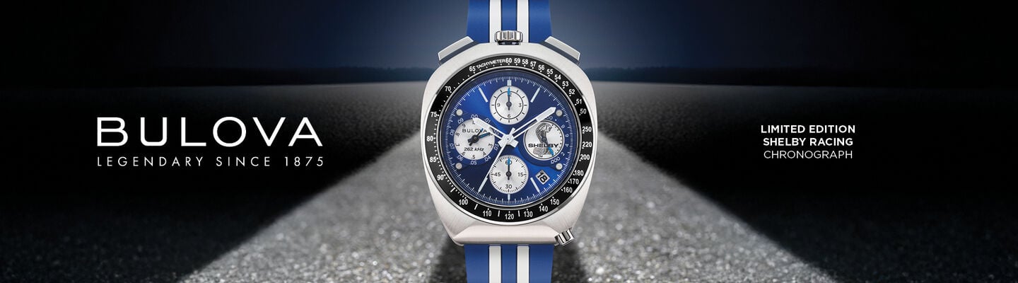 Bulova Limited Edition Shelby Racing Chronograph watch with blue and white racing stripe strap displayed on a road background.